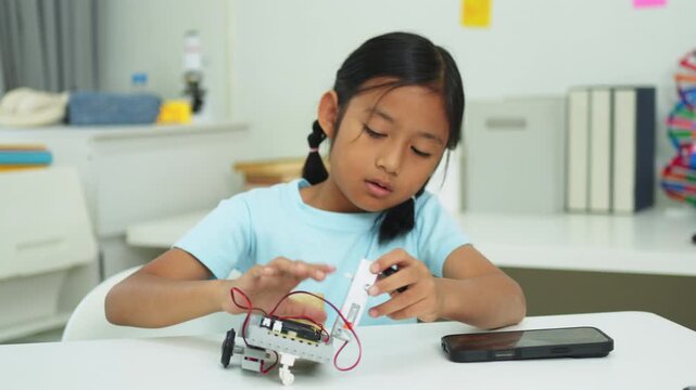 Young girl having fun working on a robot design