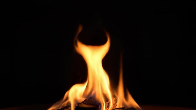 A closeup view of a burning flame with smoke on a dark background