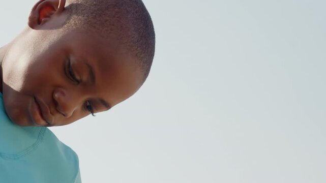 Young athlete shifts focus confidently. Young male athlete transitions from reflection to strong determination. Male youth athlete moves from introspective thought to resolute and focused expression