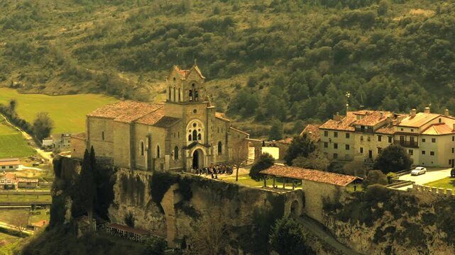 Vista a&eacute;rea cinematogr&aacute;fica del conjunto medieval de Fr&iacute;as, con etalonaje en tonos amarillos que aporta tensi&oacute;n y misterio. La arquitectura sobre la roca emerge entre sombras, evocando historia y sile