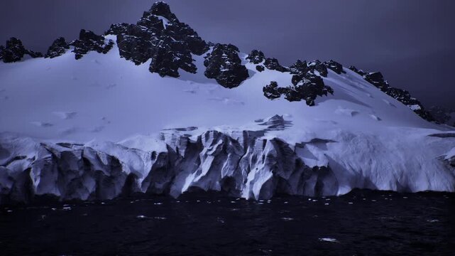 blue hued ice cliff at dusk, towering crevasses and fractured seracs meet rough ocean, waves crashing at base, dramatic texture and scale, compelling image