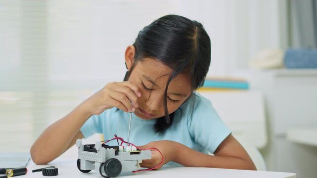 Young girl having fun working on a robot design