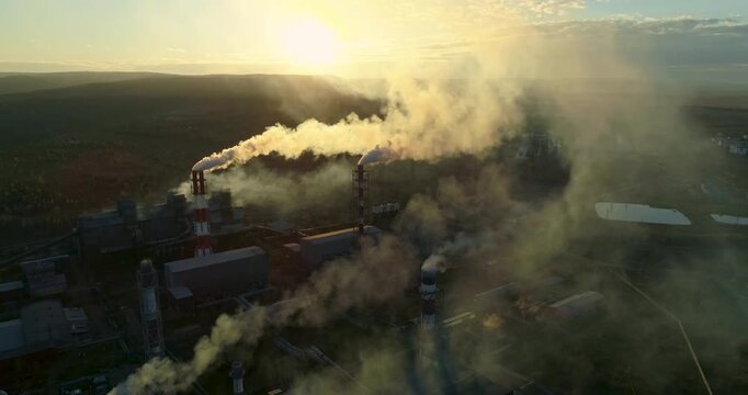 Metallurgical production smoke emits from the factory chimney. Top view of heavy industry plant smoking smokestacks at sunset Environmental pollution. Steel factory panorama Aerial 4K