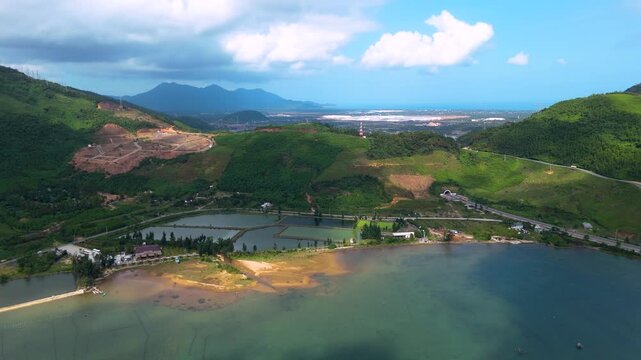 Aerial view of the Lagoon and Oyster Farm, with lush green hills contrasting the water, creating a beautiful landscape, tt. Lang Co, Hue, Vietnam.