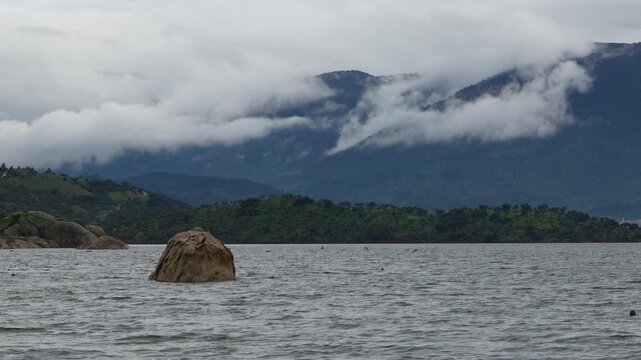 Dramatic View of a Solitary Rock in Bafa Lake with Latmos Mountains and Foggy Clouds, Turkey. High quality 4k footage