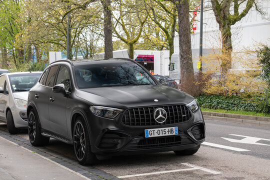Nancy, France - March 31st 2026 : View on a matte black Mercedes-AMG GLC 63 S 4MATIC+ parked on a street with a car behind and trees in the background.