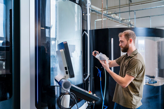 Young man operating machinery in a production hall