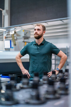 Young male engineer in a production hall with machinery