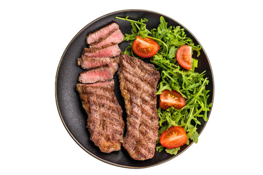 Grilled Steak from Black Angus beef meat on a plate with salad isolated on white background