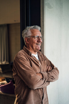 Grandfather smiling indoors at home looking forward to the future