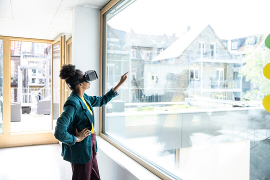 Businesswoman using AR glasses and interacting in modern office