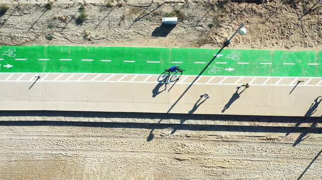 Aerial view of Shlomo Lahat Promenade, where the vibrant green of the bike lane contrasts with the sandy beach, creating a striking visual harmony, Tel Aviv-Yafo, Israel.