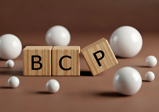 Three wooden blocks with the letters bcp displayed alongside multiple white spheres on a textured surface in a studio setting