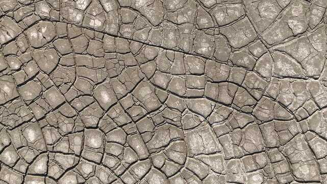 Aerial view of cracked dry earth and parched mud texture with intricate patterns in the Rio Tinto mining area in Minas de Riotinto, Andalusia, Spain.