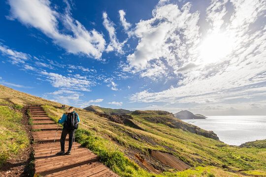 Tourist hiking on PR 8 trail in Madeira with coastal landscape
