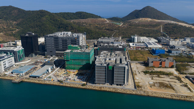 New Territories, Hong Kong - 14 February 2026: Aerial view of the Data Technology Hub and industrial buildings along the waterfront with green hills.