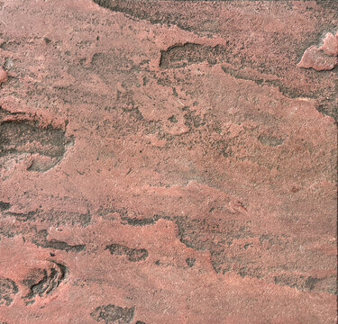 Close up of natural rock stone granite with rough 3D texture in pink red color. Rough natural slate stone slab, suitable for exterior floor and wall material finishes. Seamless background texture