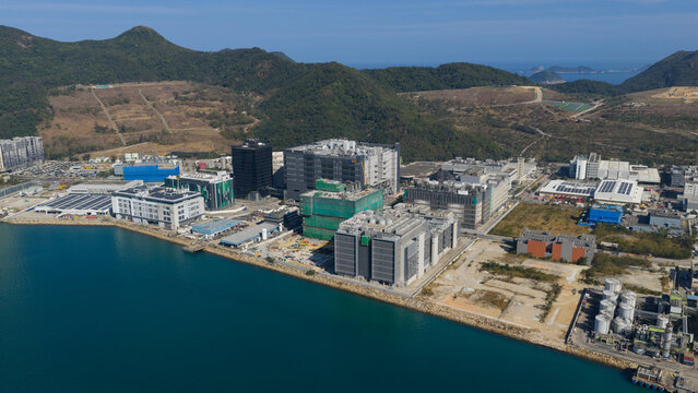 New Territories, Hong Kong - 14 February 2026: Aerial view of the Data Technology Hub and surrounding industrial complex along the waterfront of Tseung Kwan O with lush green hills under a clear sky.