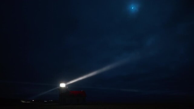 Distant lighthouse glowing through coastal fog at night near Mendocino, California, USA with soft light beam cutting through mist and creating atmospheric moody coastal scene