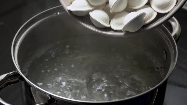 Dumplings are cooked in boiling water. The process of making homemade meat dumplings. Frozen dumplings are dropped into boiling water, stirred, and brought to a boil. Homemade semi-finished products