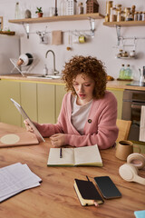 Curly woman in pink cardigan working at home a peaceful spring morning © Bliss