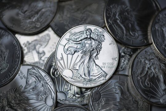 Collection of silver dollar coins stacked in a pile, representing wealth, currency, and financial success