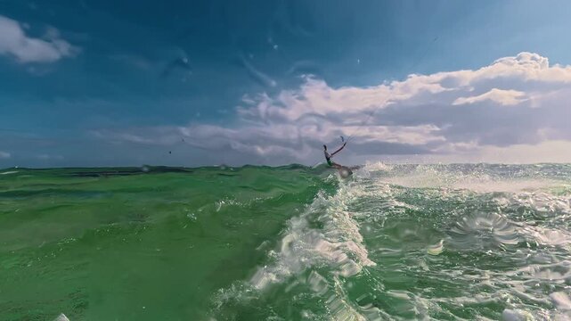 A teenage boy kitesurfs in crystal clear water on a tropical island on a sunny day. Extreme sports