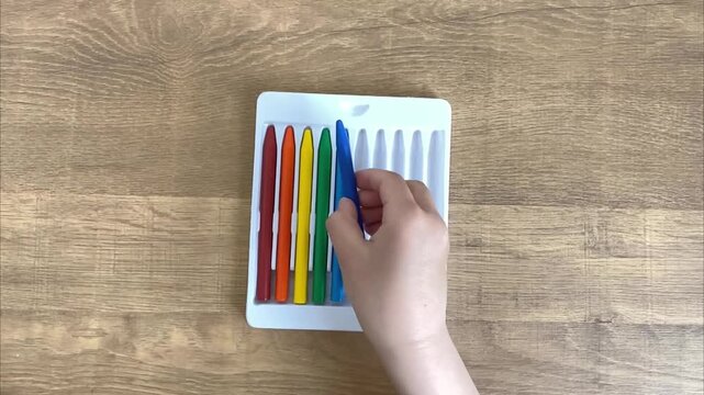 Child putting back sixth colored marker into case slow motion