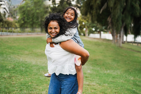 Happy indian mother having fun with her daughter outdoor - Family, mom day and love concept - Main focus on mum face