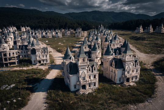 View of the abandoned Burj Al Babas housing development featuring rows of identical castle-like villas under dark clouds and shadows in Dolayuz, Bolu, Turkiye.