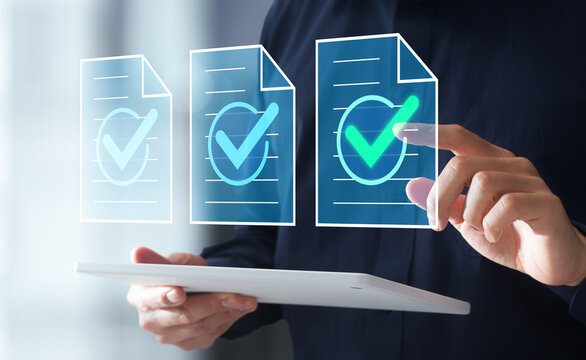 Document management system. Legal agreement document with a check mark. Businessman using digital tablet to tap file icon.