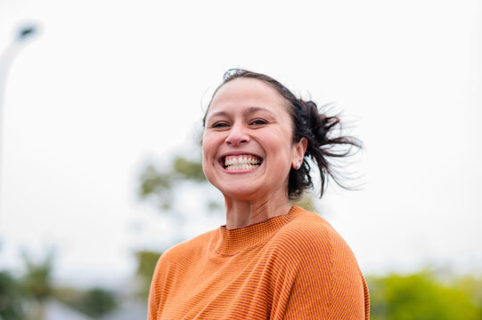 Portrait of an adult woman laughing while standing outdoors in Auckland