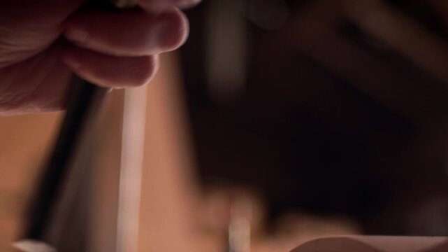 Female artisan carefully striking a chisel with a mallet to shape a wooden piece. Slow motion, close-up.