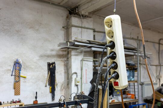 Extension power strip with plugs hanging in workshop interior