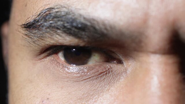 Extreme close-up of a man's brown eye with a furrowed brow, expressing anger, suspicion, and intense focus. High-quality macro shot.
