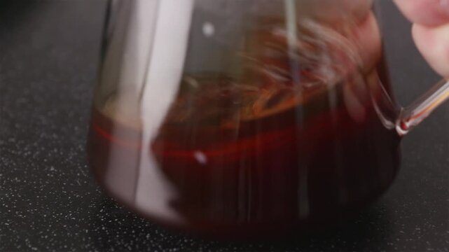 Close-up of coffee aeration and swirling in glass server