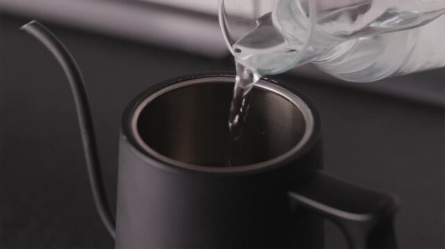 Close-up of water pouring into professional coffee kettle