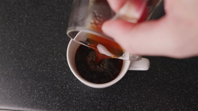 Top shot of pouring finished filter coffee into white mug