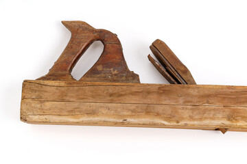 Old wooden plane used for carpentry work on a plain surface