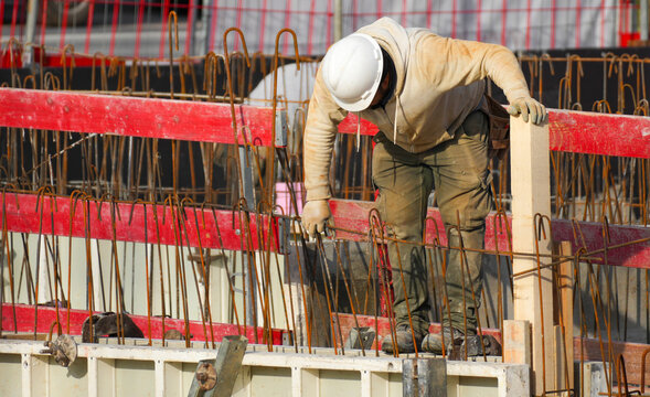 A builder works manually with tools on construction site, showing a heavy working process.