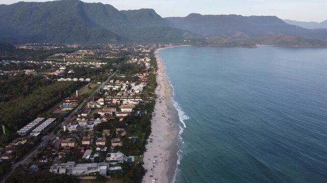 Aerial 4K view of Maresias beach coastline and village surrounded by mountains in Brazil