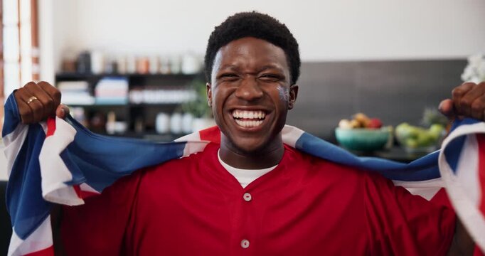 Celebration, face and flag of United Kingdom with black man watching tv in home living room. Cheering, Great Britain and support with excited fan in apartment for streaming service or subscription