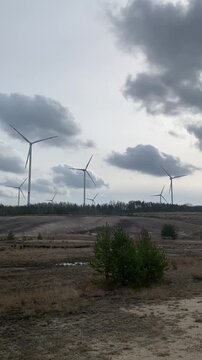 Windr&auml;der in offener Landschaft bei Tageslicht, nachhaltige Energiegewinnung unter bew&ouml;lktem Himmel, modernes Umwelt- und Klimakonzept