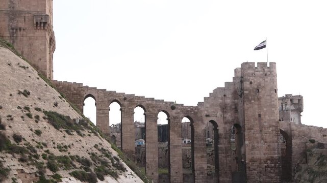 Close-up view of the massive stone fortifications and defensive walls of the Citadel of Aleppo, Syria. Iconic medieval fortress architecture and historical heritage site