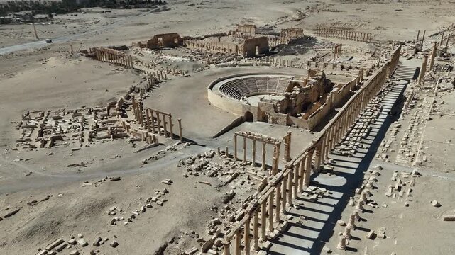Cinematic aerial shot of the archaeological site of Palmyra, Syria, showcasing ancient Roman ruins and columns