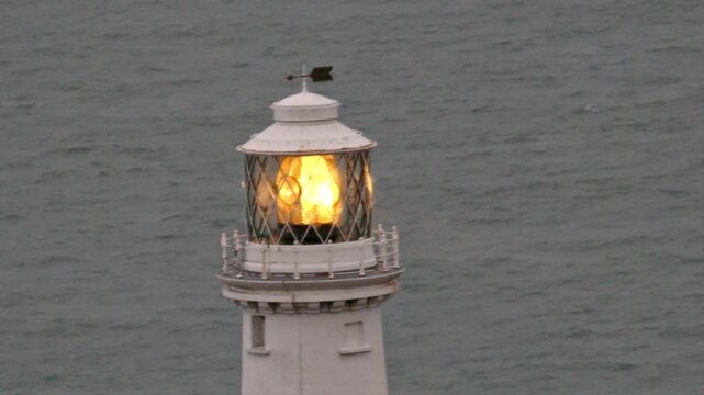 South Stack lighthouse close up light beam slowly moves across the Irish sea from Holyhead island