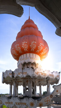 View of the ornate orange dome and white tiered structure of the Arya Dewaker Hindu temple under a clear blue sky in Paramaribo, Paramaribo District, Suriname.