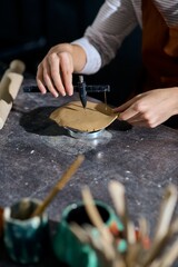 Young woman explores her creativity in a pottery studio while sculpting clay with joy © LIGHTFIELD STUDIOS