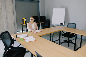 Naklejka premium Business woman writing notes in modern meeting room