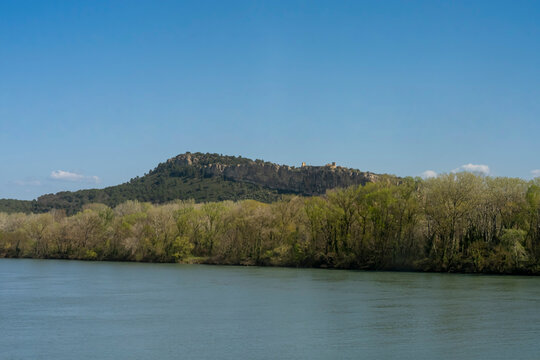 The Fortress of Mornas, France - 03 19 2026: View The fortress, perched on a rocky escarpment on the left bank of the Rh&ocirc;ne river in sunny spring blue sky